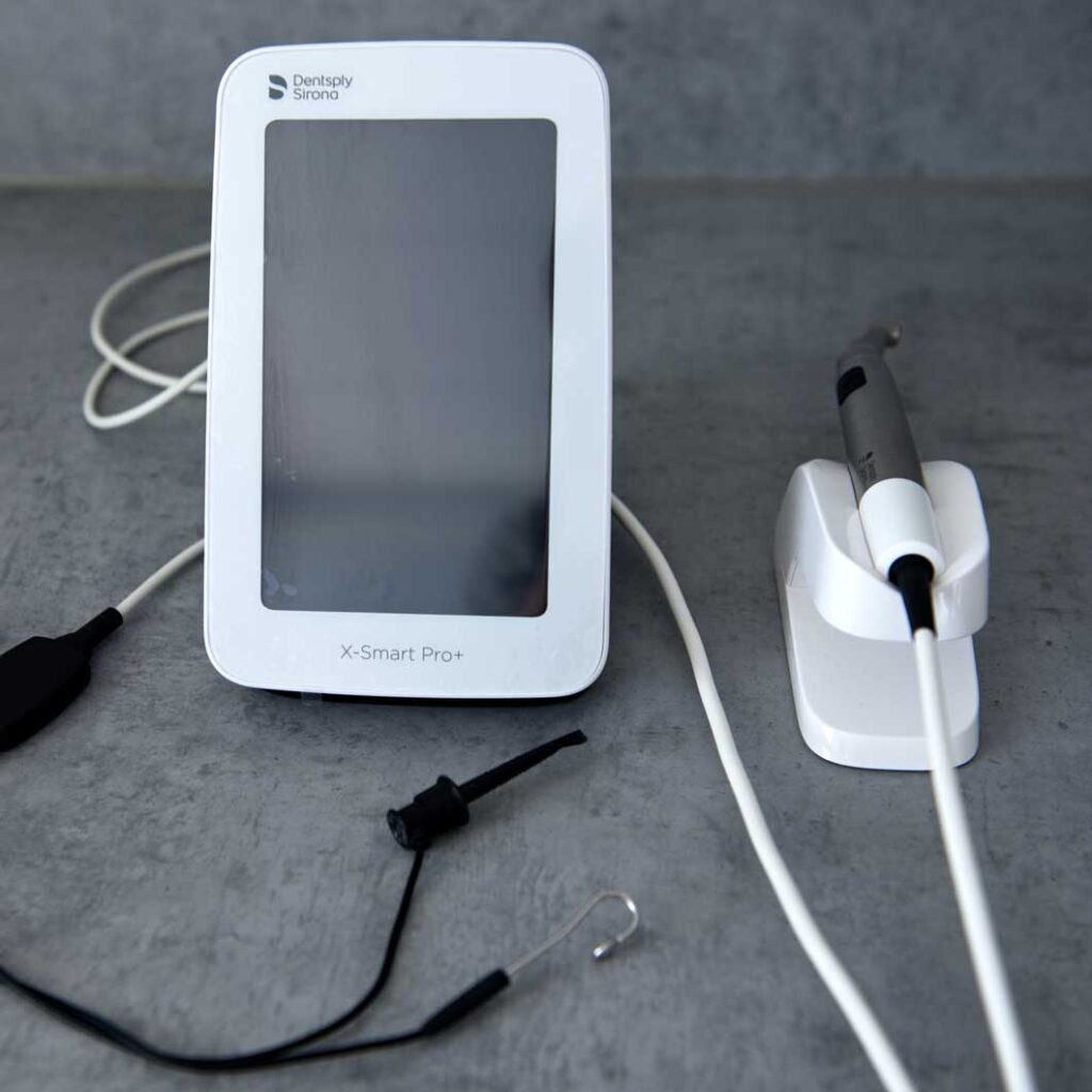 Endodontický přístroj s displejem a ruční násadec.