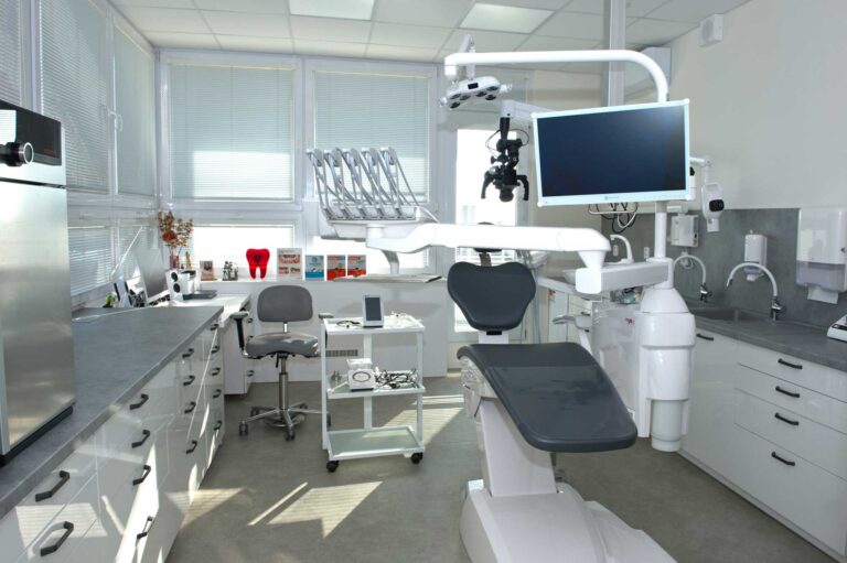 Zubní křeslo s mikroskopem a obrazovkou.