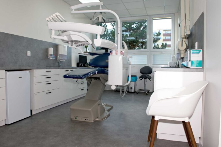 Moderní zubní ordinace s křeslem a monitorem.